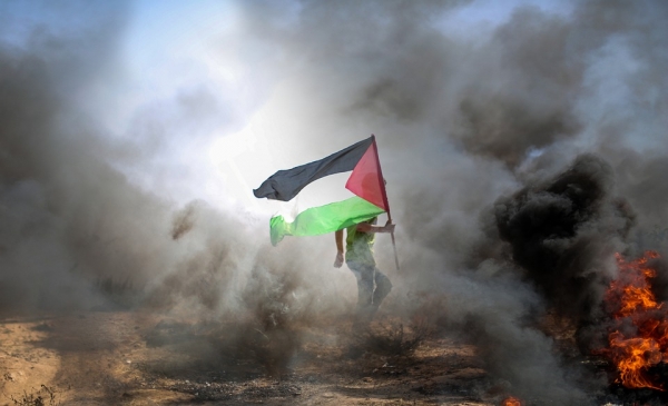 Palestinian flag near the flames