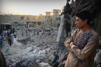 A young man looks across the devastation caused by a massive truck bomb in Kabul, Afghanistan, on Aug. 7, 2015.